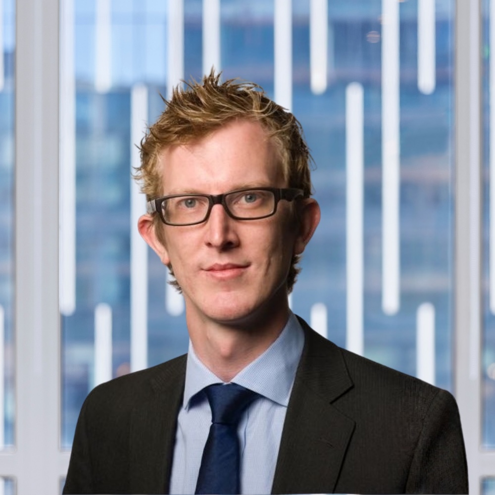 Daniel Rawling wearing a black suit and black glasses.